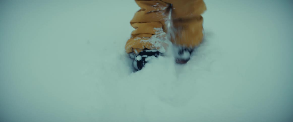Person in yellow snowsuit trudging through the snow