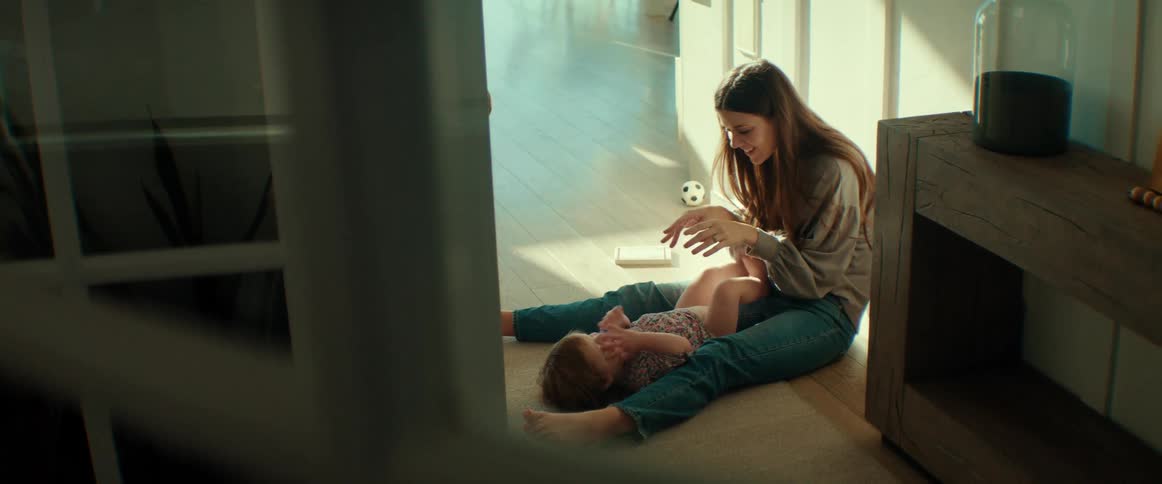 A mother playing with her toddler while sitting on the floor