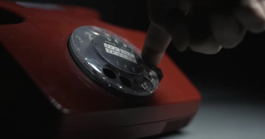 A person dials on an old rotary phone