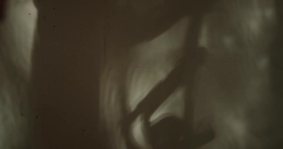 Woman casts shadow on wall while working out on elliptical machine
