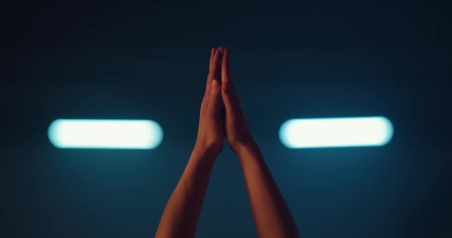 A woman stretching her arms upwards in a yoga pose