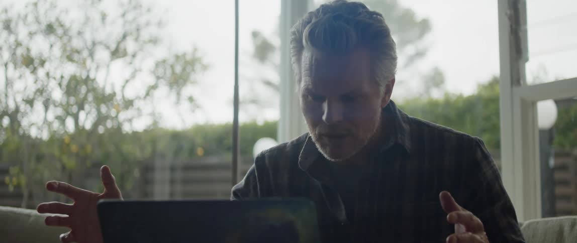 A man is talking on his laptop
