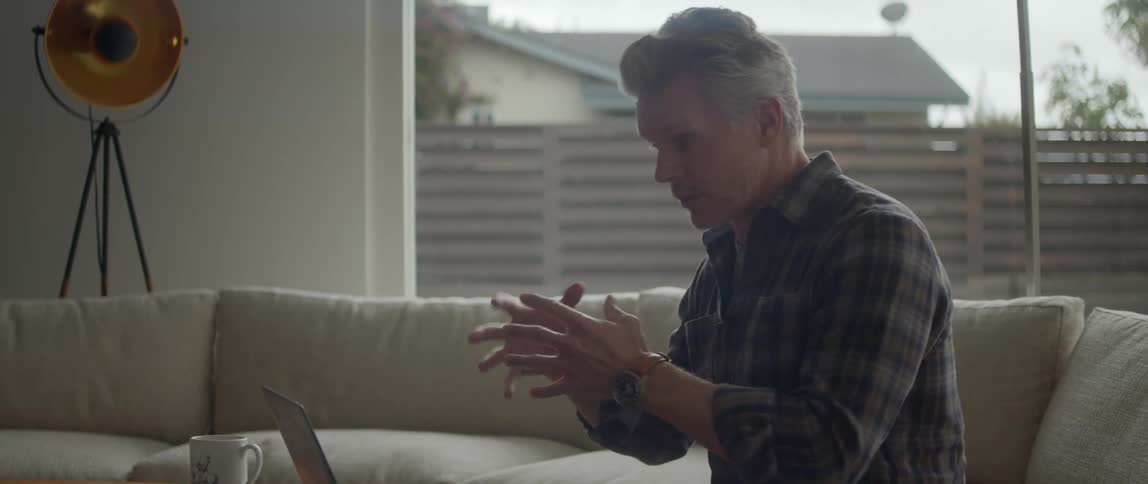 A man is talking to someone virtually on his laptop