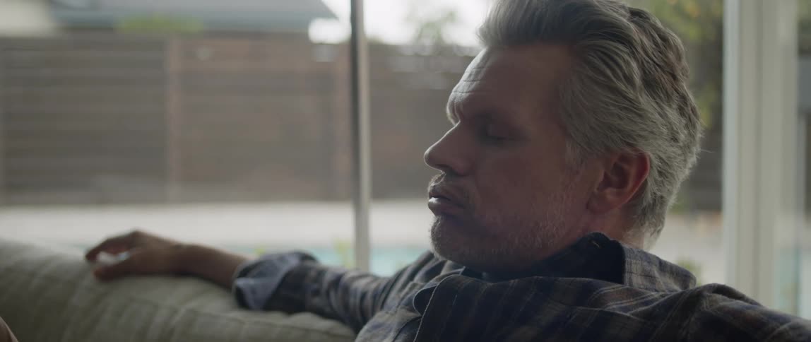 A man is sitting on a couch during the spring time