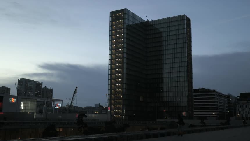 A tall building sits in a cloudy sky