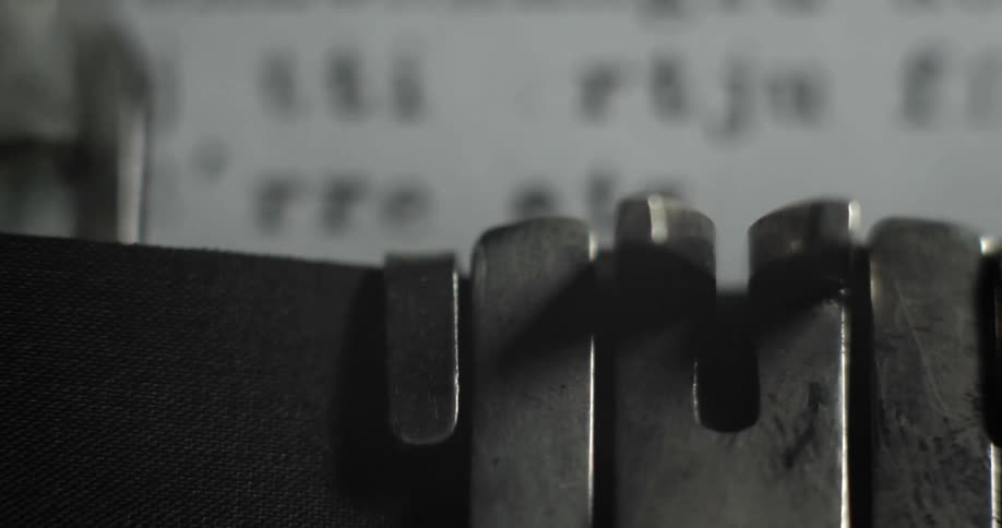 A typewriter strikes against paper