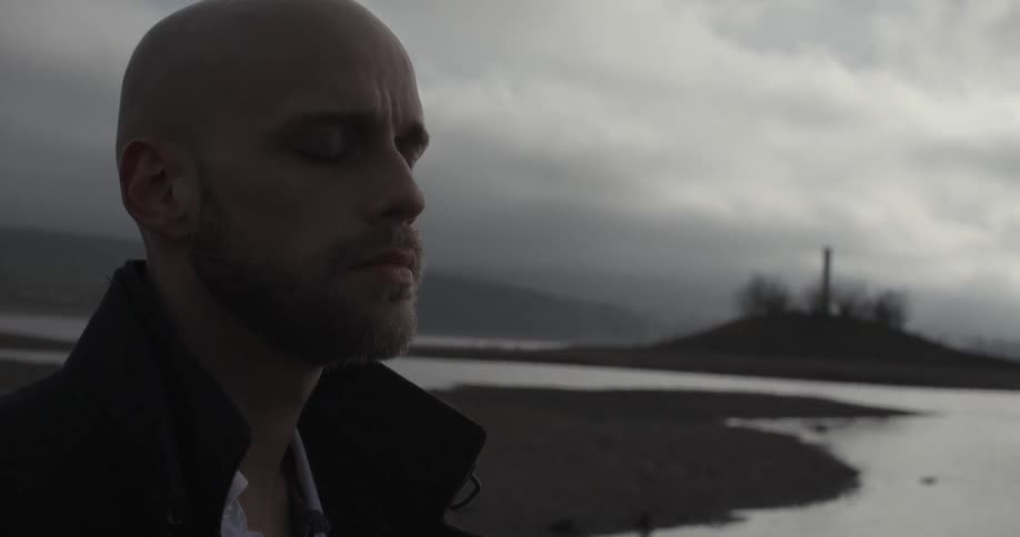 A man meditates by a lake