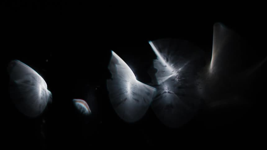 Close up of light being distorted reflecting on glass against a dark background