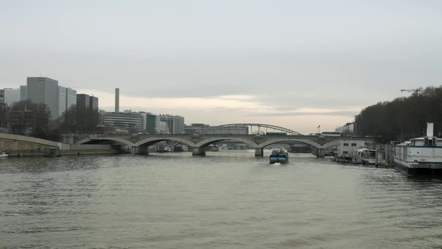 Boat traveling along a waterway under a bridge