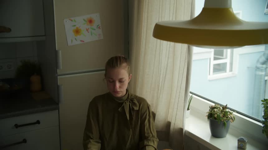 Woman sitting in the kitchen on her apartment