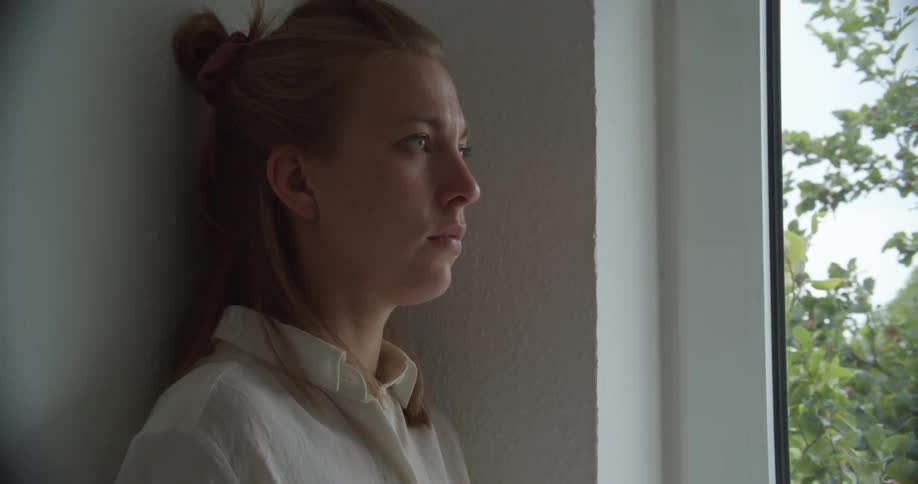 A woman walks from the window