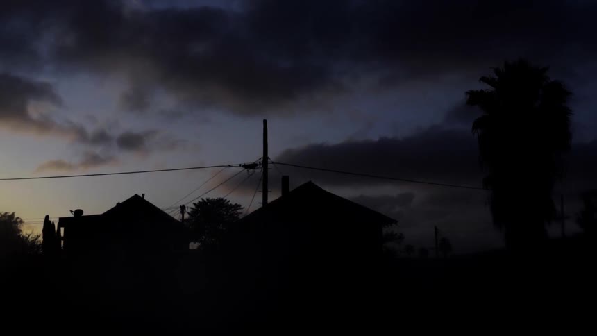 Clouds hovering over homes as night falls