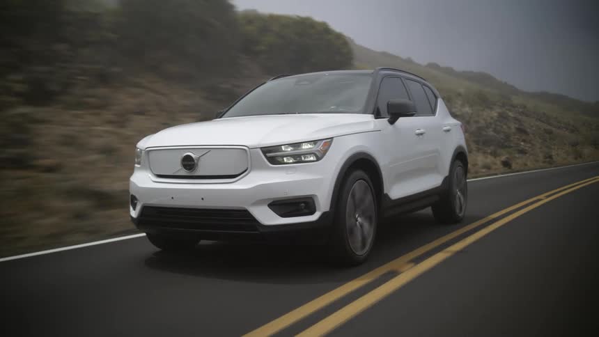 A white suv traveling on a remote road on a foggy day