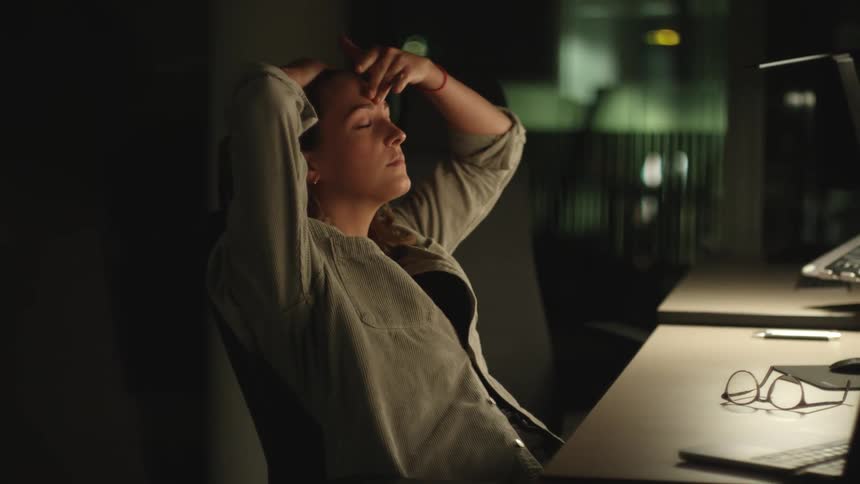 Woman in blue shirt sits back in chair at the studio