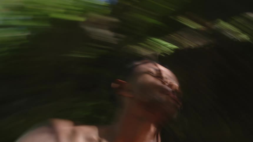 The view is of a man dancing around the jungle