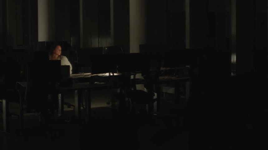 Employee works late and alone at a dark office