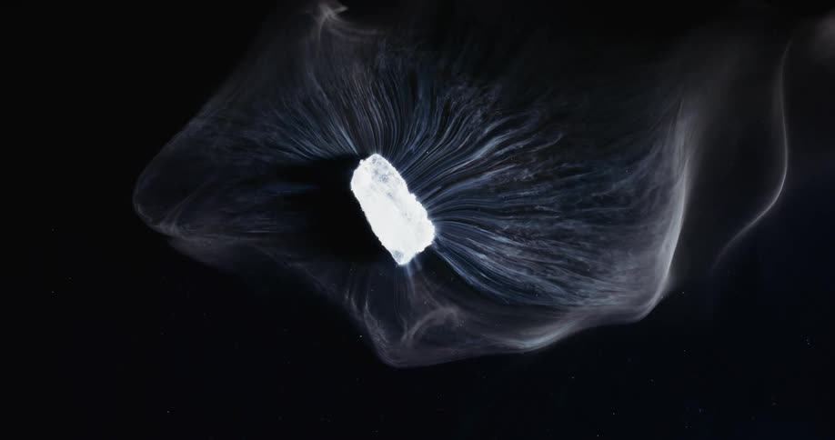 Gaseous layers spread from bright crystalline chunk against starry sky