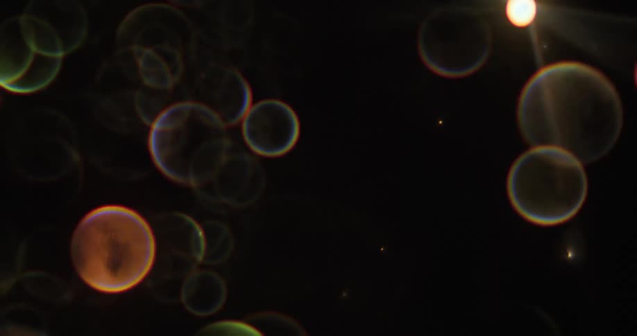 Bubbles with a rainbow edge pop up against a black background