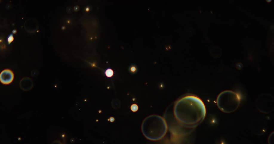 Shimmering light bubbles pop against a black background