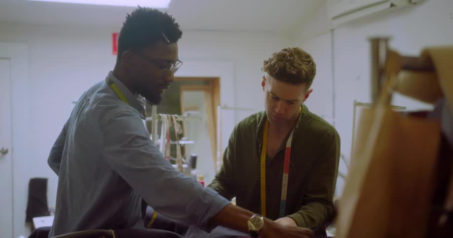 Two men discuss a piece of fabric they are holding