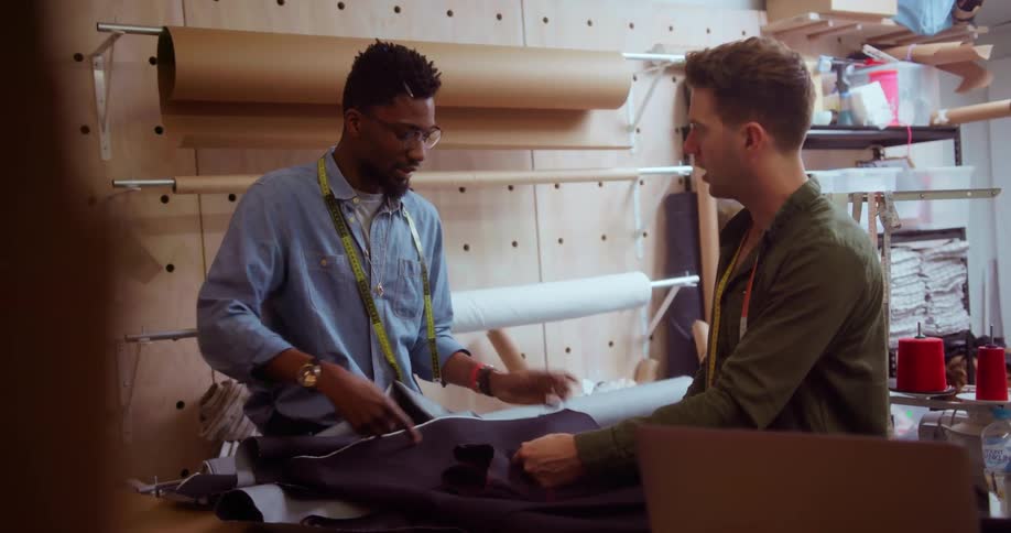 Two men converse while looking at fabric