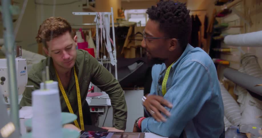 Two fashion designer talk while at work