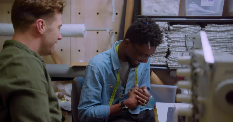 Two men talk and laugh at work