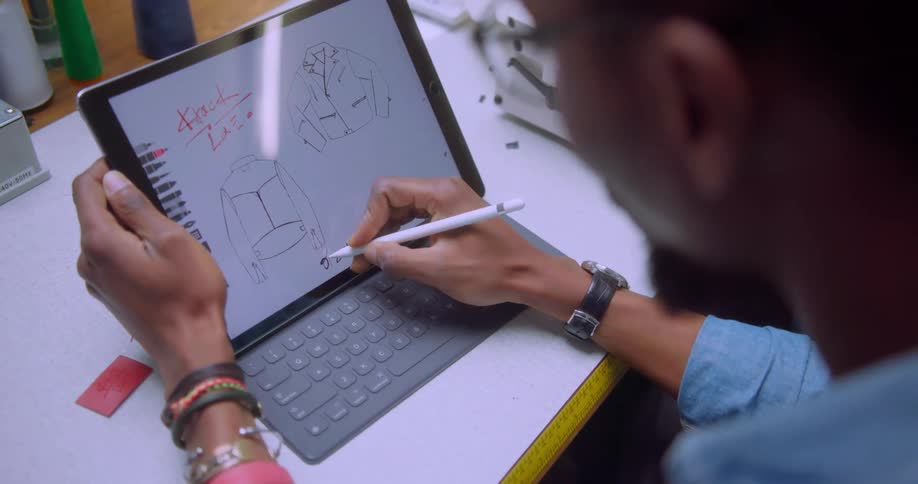 A fashion designer draws on a tablet