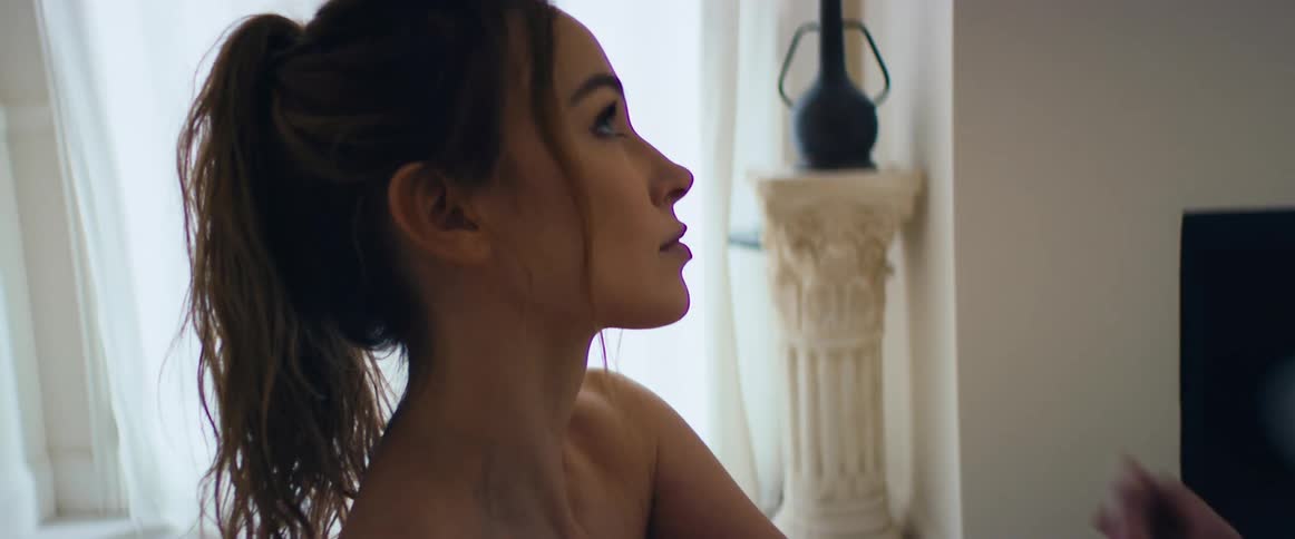 A woman wearing all white is practicing yoga in her home