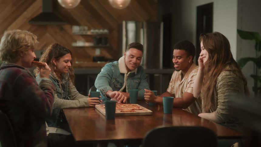 A group of friends eat pizza in a cafe