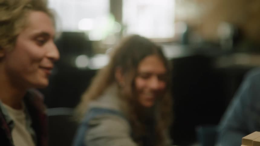 Two friends high five while hanging out in a group