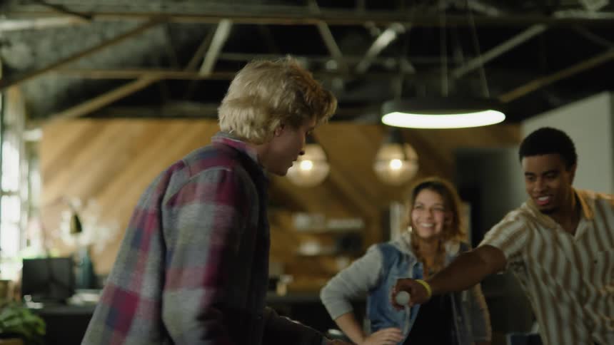 Friends watch other friends play ping pong