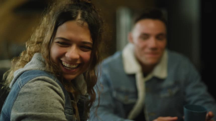 A small group of people are sitting at a table laughing and talking