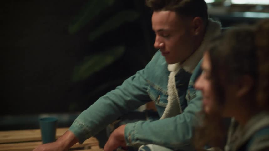 Friends sit around coffee table playing a board game