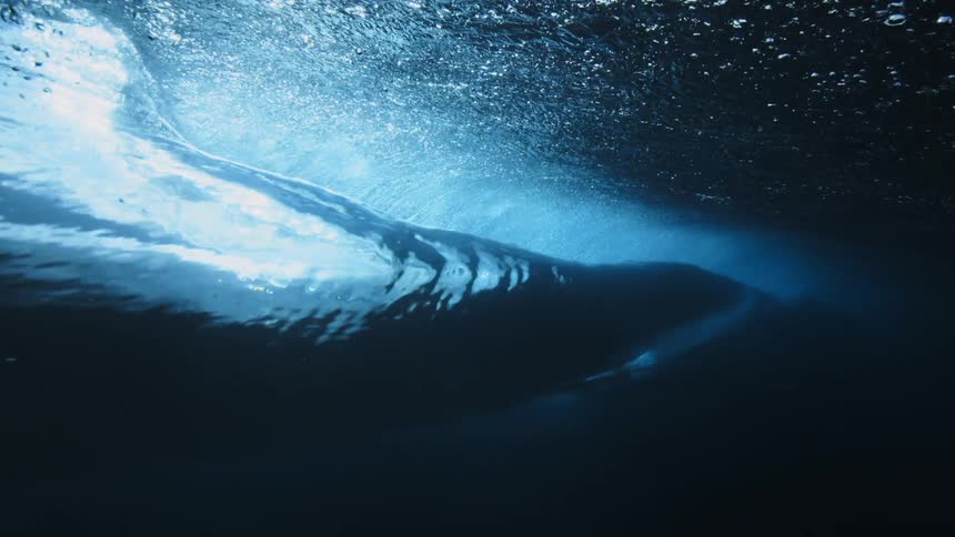 A surfer rides a wave in the ocean