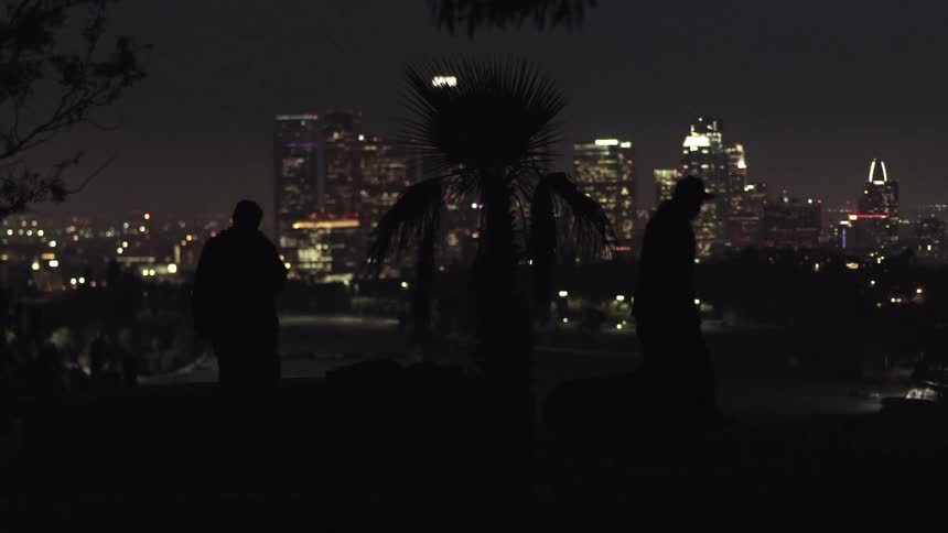 Two men walking through a city at night