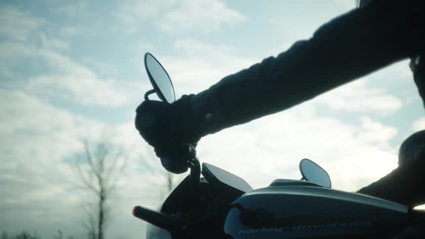 Bikers wearing black helmets and coats ride motorcycles on highway