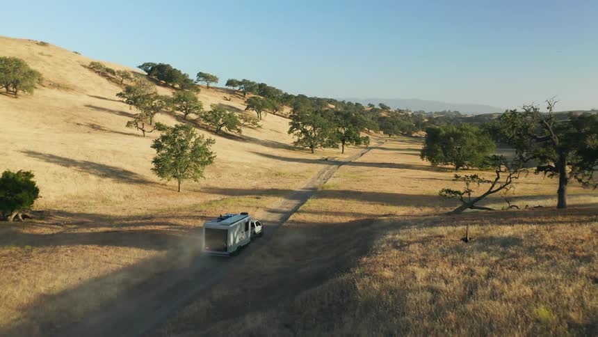Aerial view of pickup truck with mobile home driving on country road