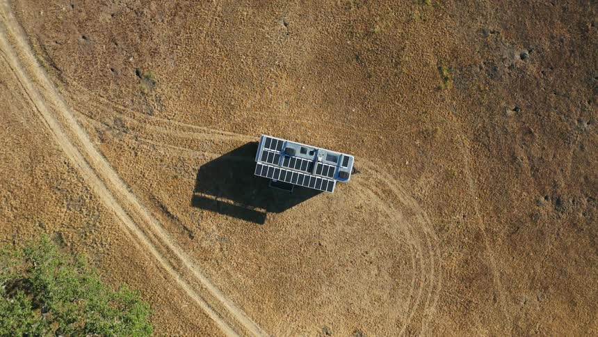 An aerial view of a parked rv with solar panels