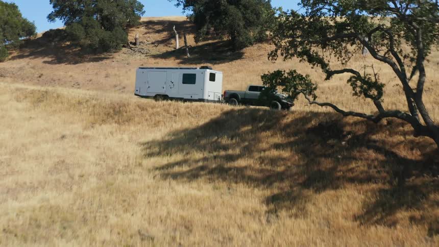 A truck hauls a trailer down a road