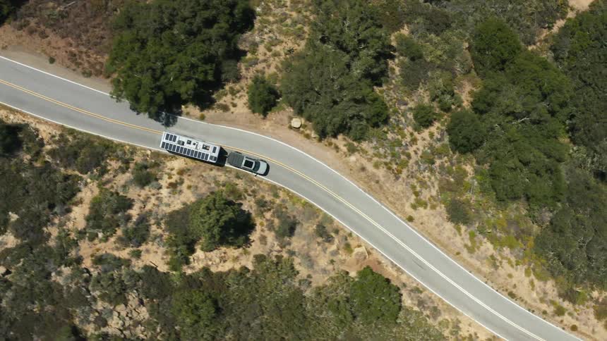 A truck is dragging a trailer with solar panels