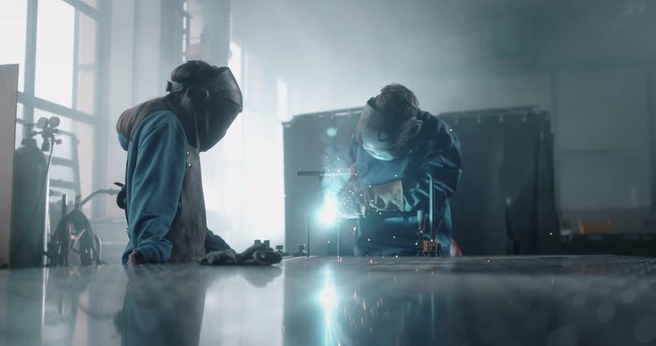 Two men are welding in the factory