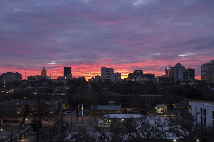 Clouds passing by as traffic flows through a city during sunrise