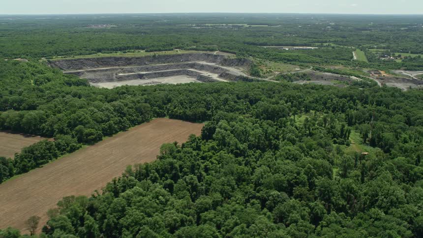 Aerial footage of farmland and an industrial quarry in Kingston New Jersey on a sunny day