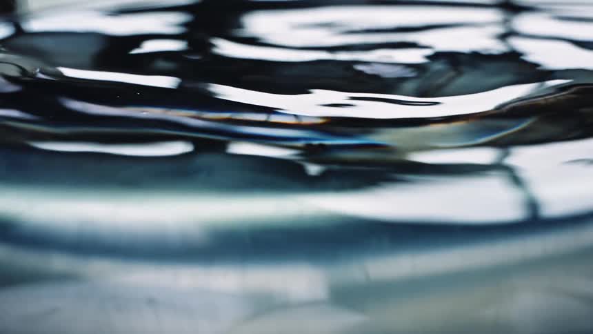 Rippling water reflects light and surroundings