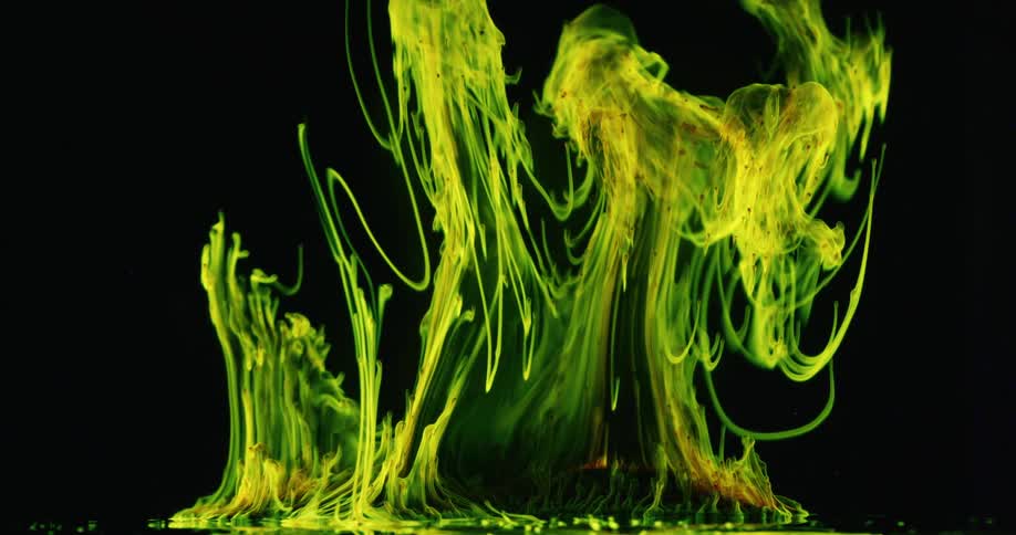 Abstract yellow and green smoke rises up on black background