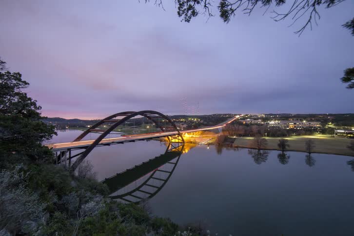 Vehicles travel along a bridge at dawn