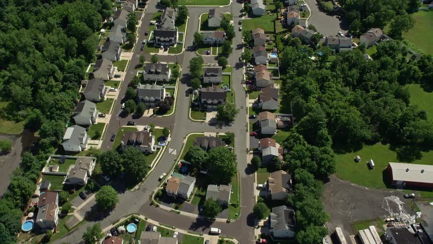 Approaching sunny townhouses in Trenton New Jerseys residential neighborhood from an aerial 