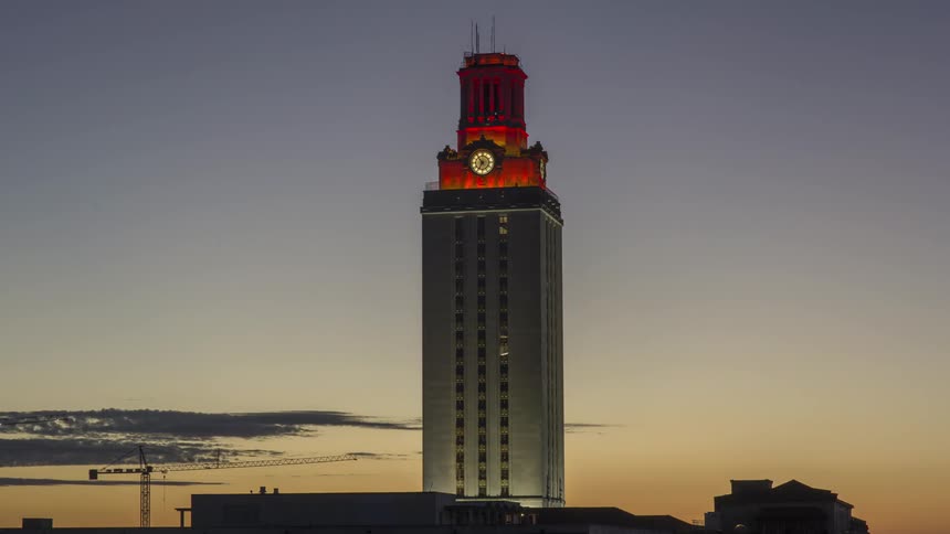 A building with the top lit red at sunrise
