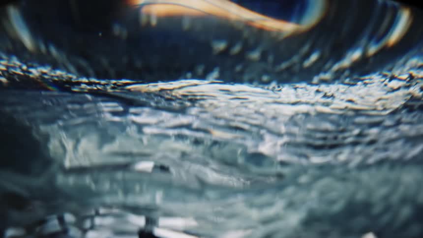 Liquid waves and swirls in front of a lit background